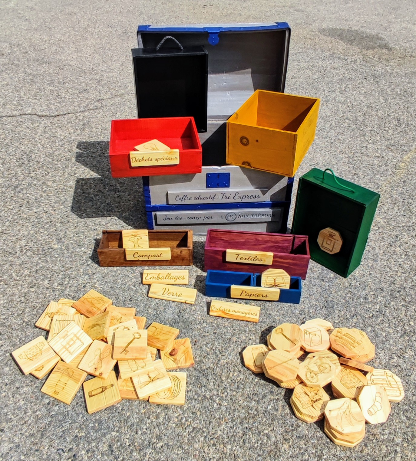 Jeu pédagogique de tri des déchets en bois avec différentes catégories : compost, verre, emballages, textiles et déchets spéciaux.